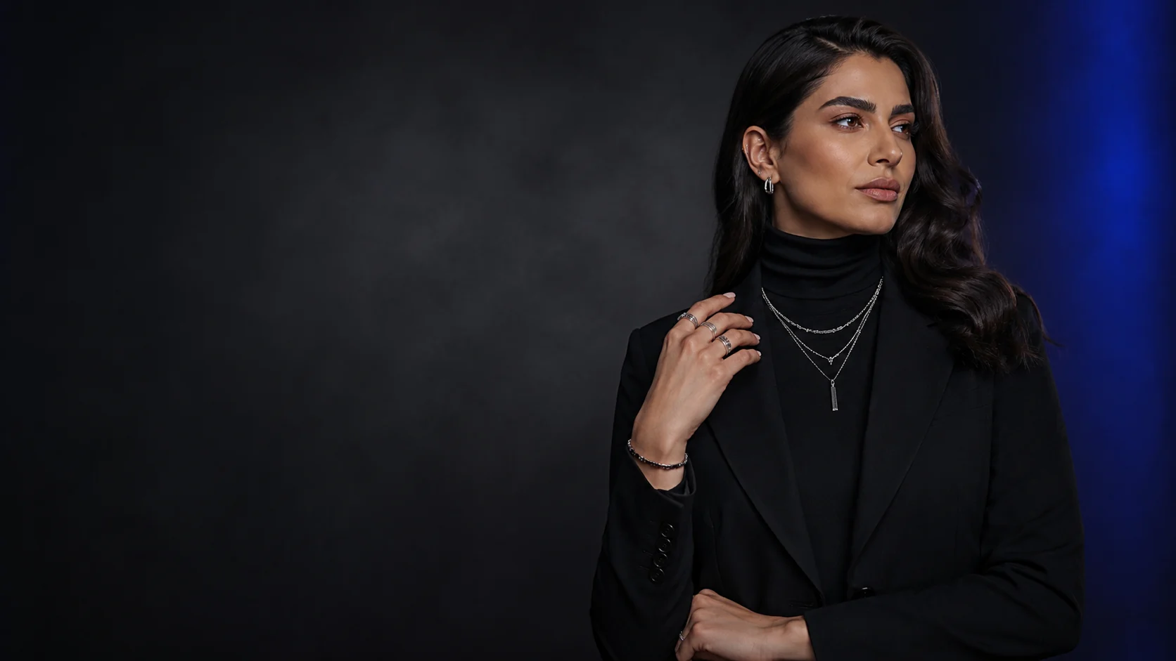 Woman wearing layered contemporary silver jewellery